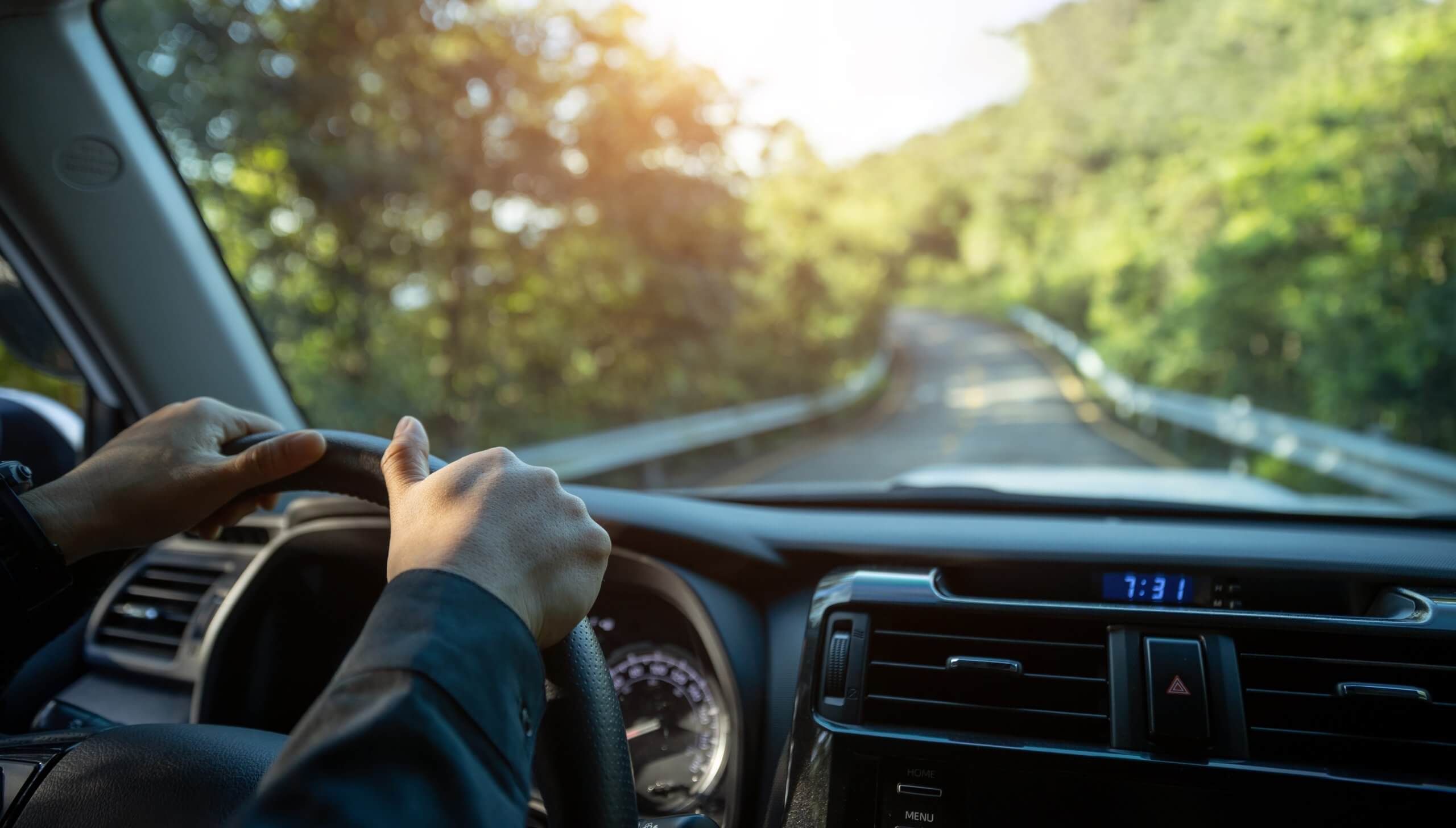 A picture inside a car of a person driving down a highway.